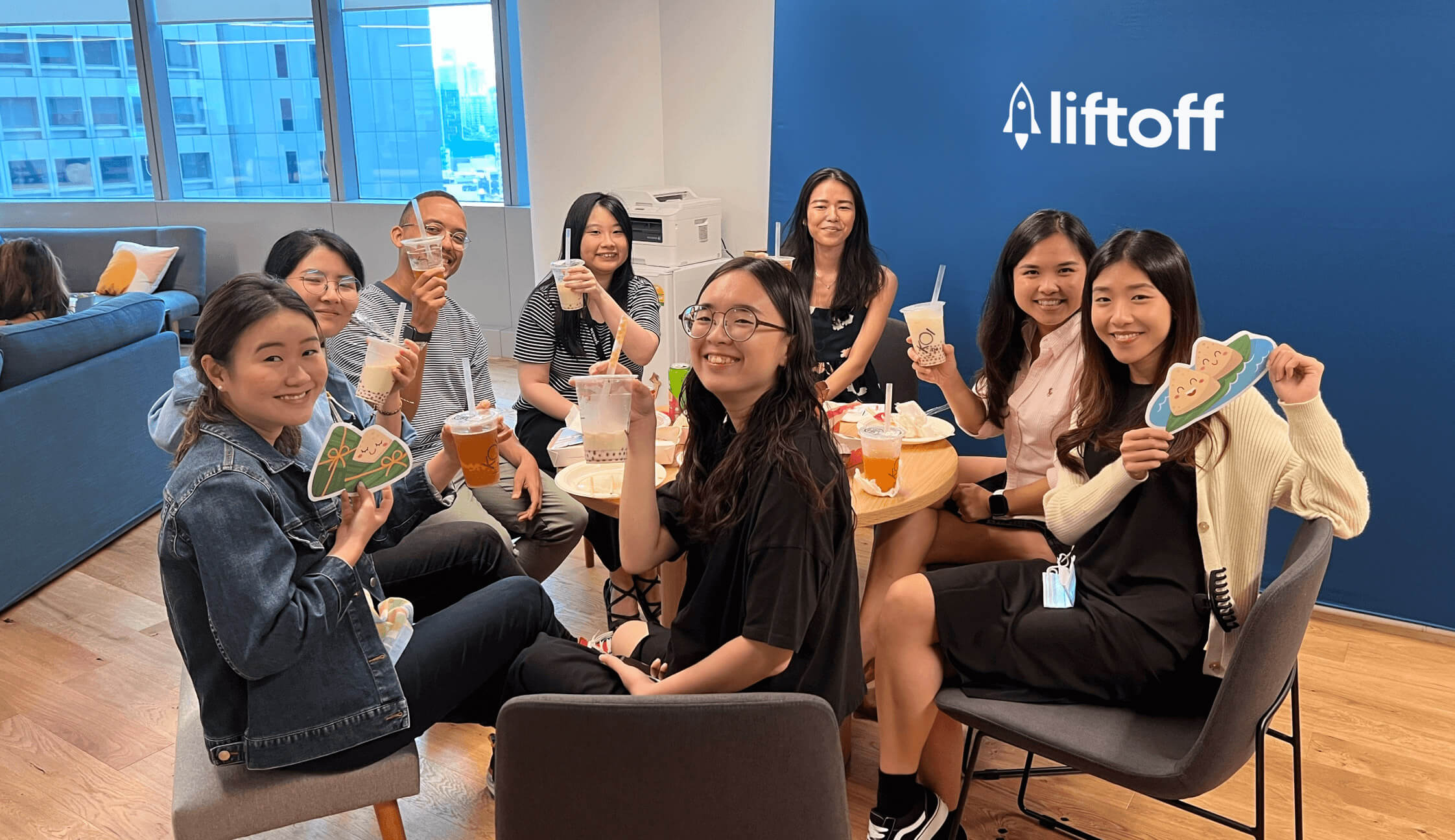 A group of Liftoff colleagues enjoy boba tea while sitting at a table in a Liftoff breakroom
